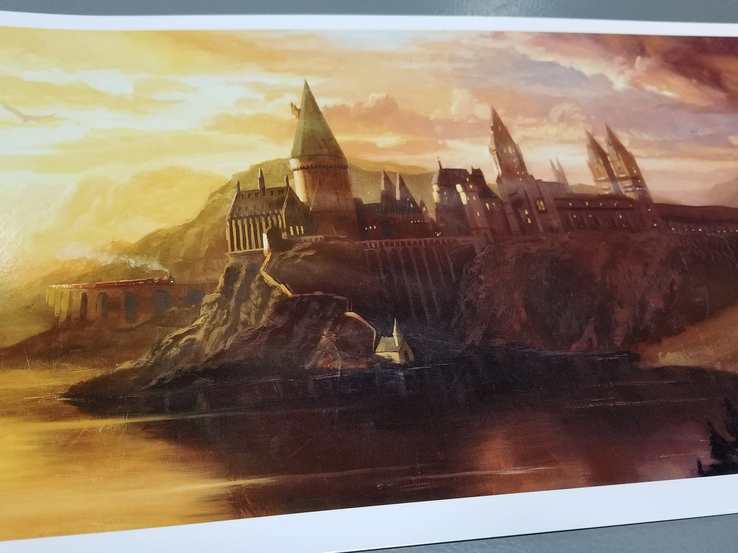 Load image into Gallery viewer, &amp;quot;Welcome to Hogwarts&amp;quot; Harry Potter Art by Christopher Clark  Stunning licensed art print of the Hogwarts castle at sunset. The Hogwarts Express is arriving, an owl flies overhead, and Hagrid&amp;#39;s Hutt can be seen.  Fully licensed fine art print, sized 10&amp;quot; x 18&amp;quot; on premium paper
